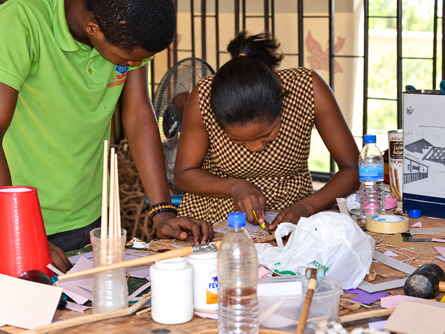 Artisan trimming woven fibre during a craft session